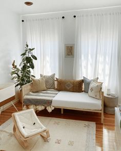 a living room filled with furniture and white curtains