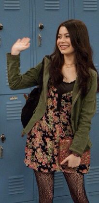 a woman standing in front of lockers with her hand up to the side and smiling