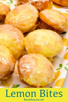 lemon bites with icing on a white and yellow plate next to orange slices in the background