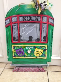 a green and red box with the word nola painted on it