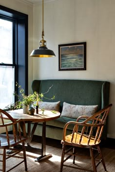 a living room with two chairs and a table in front of a large window next to a couch