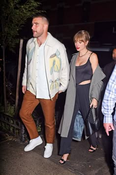 two people walking down the street at night