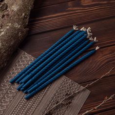 several blue candles sitting on top of a table next to a piece of cloth and some rocks