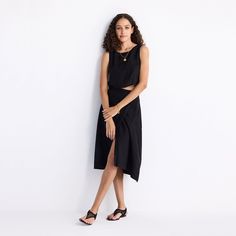 A welcome addition to your black wardrobe, this solid midi skirt with an overlap style and button detailing on the side lays out a versatile canvas for endless styling options. The skirt is crafted from Hemp fabric making it super comfy and breathable Chic Black Asymmetrical Wrap Skirt, Black Asymmetrical Wrap Skirt For Summer, Chic Midi Dress With Asymmetrical Skirt For Work, Black Midi Dress For Work, Chic Black Wrap Skirt For Work, Chic Asymmetrical Midi Dress For Work, Chic Black Midi Dress, Spring Workwear Midi Dress With Asymmetrical Skirt, Chic Midi Length Wrap Skirt For Workwear