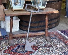 two lanterns are sitting on top of a table in front of a barrel and rug