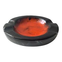 a black bowl with red liquid in it