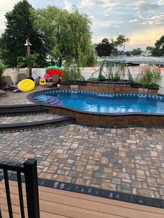 an above ground swimming pool surrounded by brick pavers