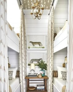 a room with bunk beds and curtains on the walls, two lamps hanging from the ceiling