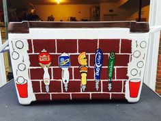 a brick wall painted with different types of beer and sodas on it, sitting in front of a door