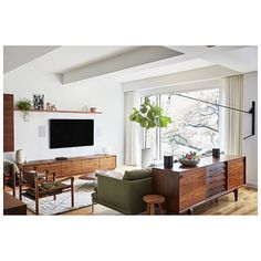 a living room filled with furniture and a flat screen tv on top of a wall