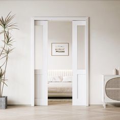 an open door leading to a bedroom with a bed in the background and potted plant next to it