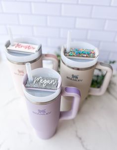 three coffee mugs sitting next to each other on top of a white marble counter