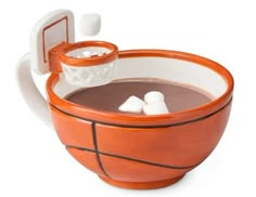 an orange and white basketball mug with ice cubes in it's rim is shown