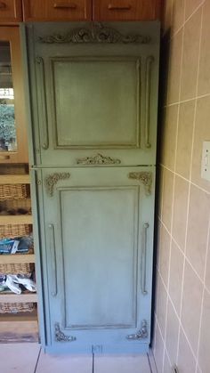 an old green cabinet in the corner of a room with tiled walls and flooring