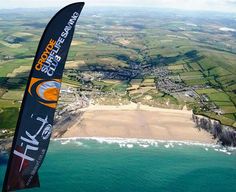 an aerial view of the ocean and land from a paraglider's perspective