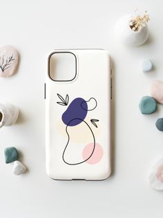 a phone case with an image of a woman's face on it next to rocks