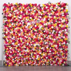 a large flowered wall is decorated with pink, yellow and red flowers