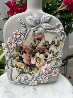 a white vase sitting on top of a marble table