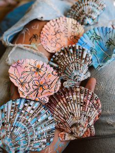 the woman's hands are holding several seashells on her lapel cover