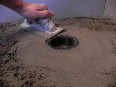 a person using a brush to clean a hole in the ground