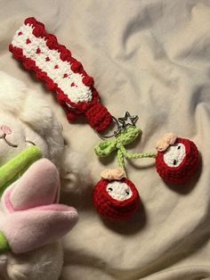 a stuffed animal laying on top of a bed next to other crocheted items