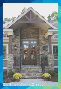 a house with two wreaths on the front door and steps leading up to it