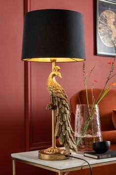 a lamp that is sitting on a table next to a vase with flowers in it