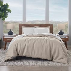 a large bed sitting in a bedroom next to two tables with lamps on top of it