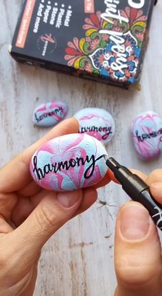 someone is holding a rock with the word harmony painted on it