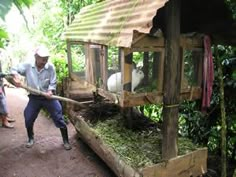 a man holding a stick near a small hut