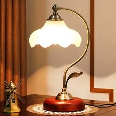 a lamp on a table next to a windmill