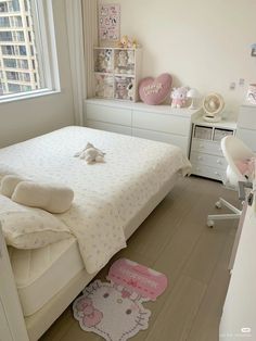 a bedroom with a hello kitty rug on the floor next to a bed and desk