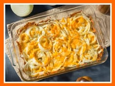 a casserole dish with cheese and onions in it on top of a table