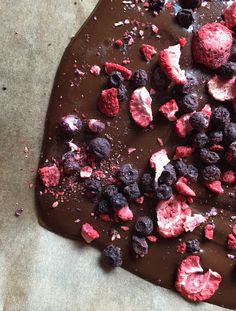 a chocolate dessert with raspberries and blueberries on top