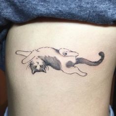 a woman's thigh with a cat tattoo on it