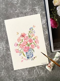 a watercolor painting of pink flowers in a blue and white vase on a table