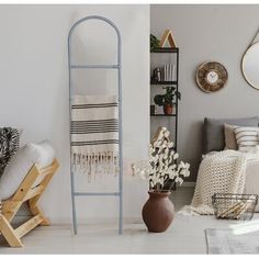 a living room filled with furniture and decor next to a wall mounted shelf full of mirrors