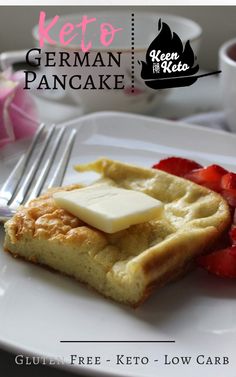 a white plate topped with waffles covered in butter and strawberries next to a fork