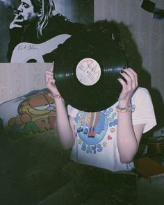 a woman holding up a record in front of her face