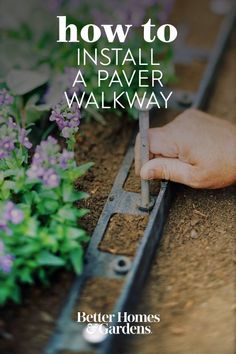 someone using a garden tool to install a flower walk way with text overlay that reads, how to install a paver walkway better homes gardens