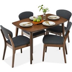 a dining table with four chairs and plates on it, set against a white background