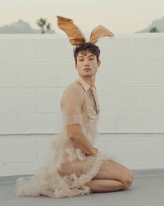 a man sitting on the ground wearing bunny ears