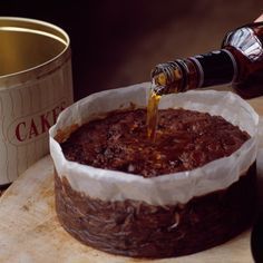 a person pours wine into a chocolate cake