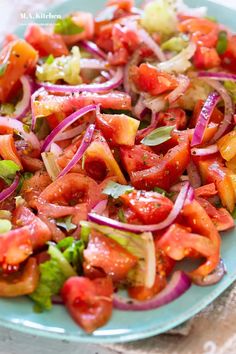 a blue plate topped with lots of veggies and onions on top of a table