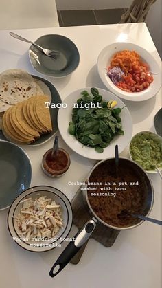 a table topped with plates and bowls filled with different types of food next to utensils