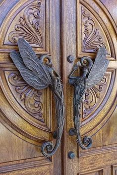 an ornate wooden door with two metal dragon handles