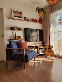 a living room filled with furniture and a flat screen tv sitting on top of a wooden floor