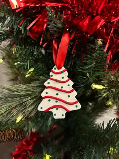 a decorated christmas tree ornament hanging from the top of a red and green christmas tree