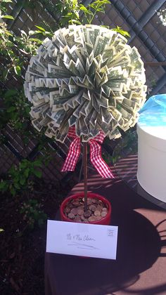 a fake money tree is on display in a pot with a note attached to it