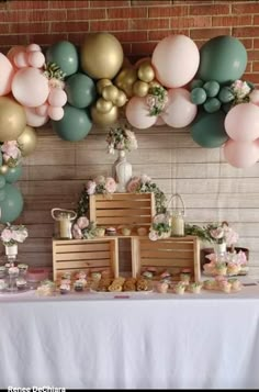 a table topped with lots of balloons next to a wall filled with desserts and pastries